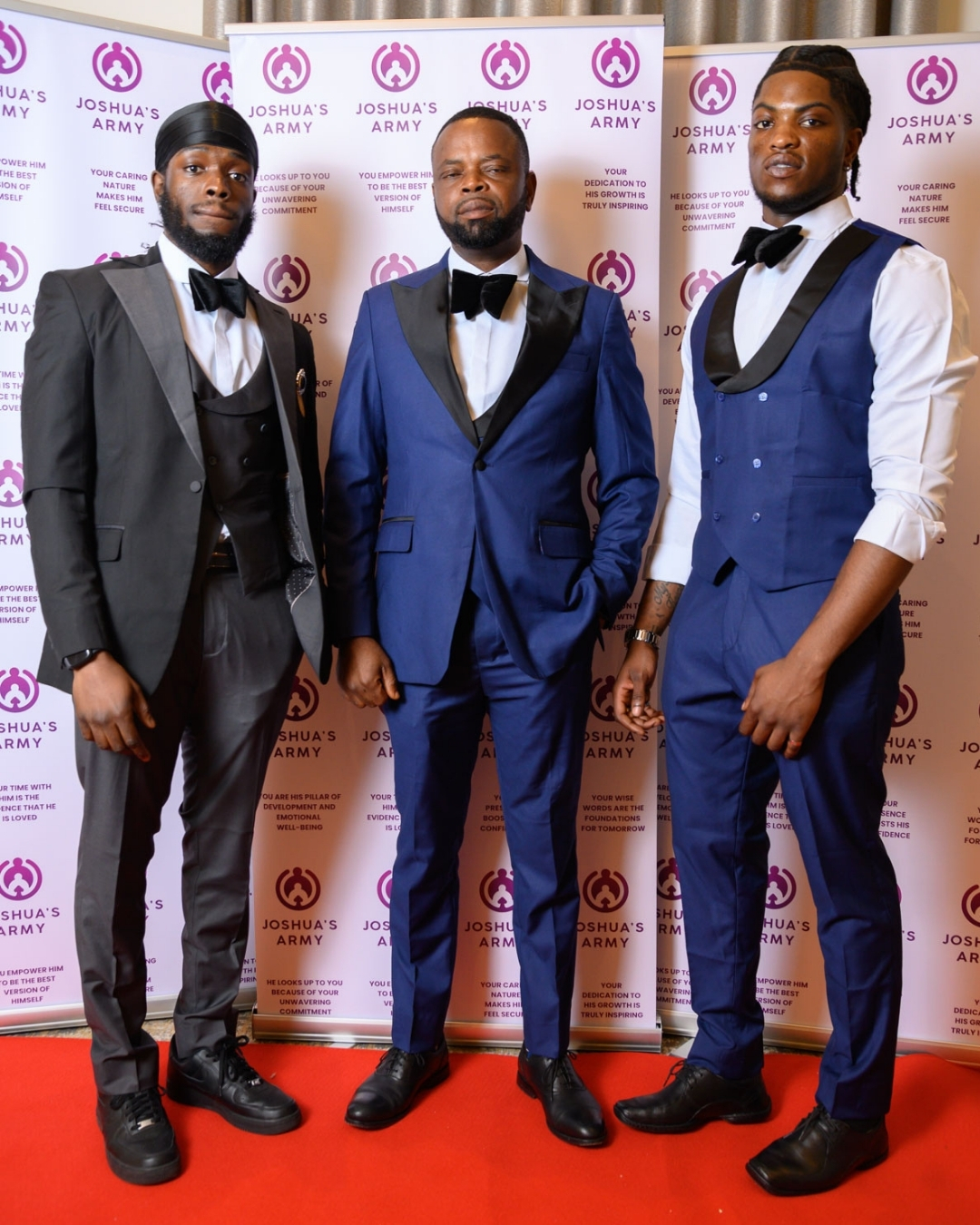 Father in royal blue tuxedo between his two grown sons