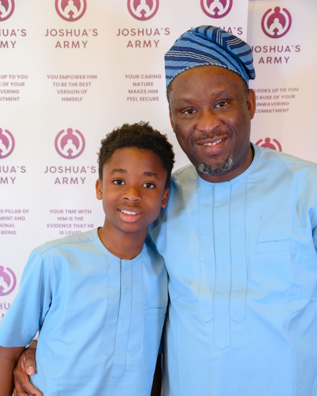 Father and son in matching traditional Nigerian light blue native attire smiling warmly